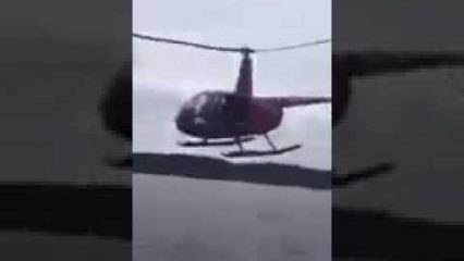 Crazy helicopter pilot flies directly through the rooster tail of a power boat