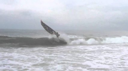 Big wave hits small boat in the ocean, janky boat jump