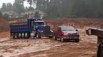 Ford F150 in the Mud Pulling Out a Stuck Dump Truck