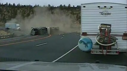 Dump truck takes corner too fast, Rolls and crashes right in front of  cop