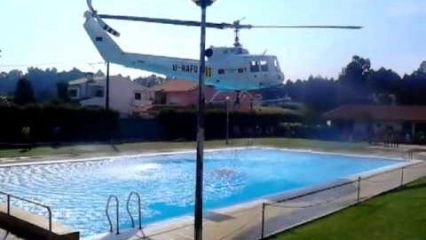 Helicopter Refills Bucket From Pool to Help Extinguish Nearby Fire